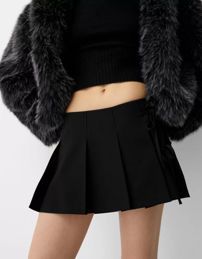 Fusta mini cu pliuri cutie cu detaliu fundita Fusta mini cu pliuri cutie cu detaliu fundita